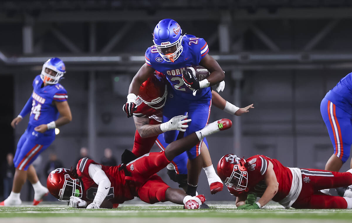 Bishop Gorman running back Noah Cole (20) runs the ball as Arbor View’s Tani Maafala-bar ...