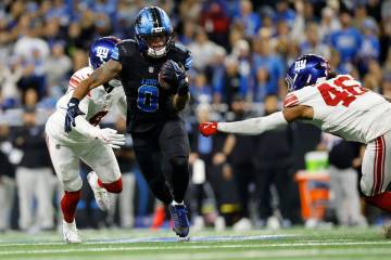 Detroit Lions running back Jahmyr Gibbs (0) runs past New York Giants linebacker Zaire Barnes ( ...