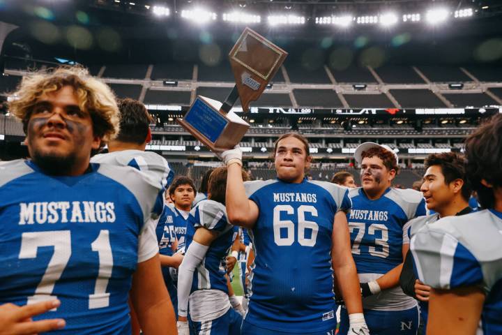 Needles Andrew Mendoza (66) holds up the trophy as the Mustangs celebrate their win in the 2A S ...
