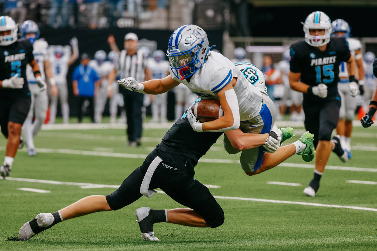 Sloan Canyon defensive back Parker Perkins (9) tackles McQueen wide receiver Aiden Hayes (8) du ...