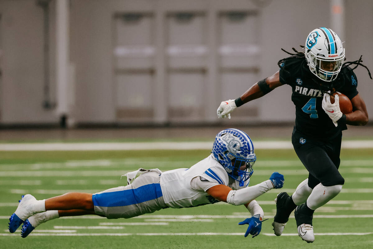 Sloan Canyon running back Jermaine Wilson Jr. (4) escapes the tackle of McQueen safety Isaiah B ...