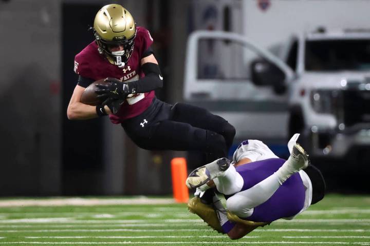 Faith Lutheran wide receiver Jaden Mason (5) gets tackled by Spanish Springs’ Marian Mar ...