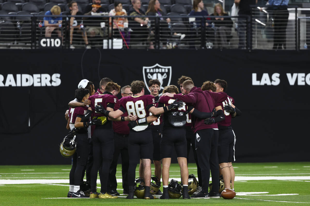Faith Lutheran players huddle before the Class 5A NIAA state football championship game against ...