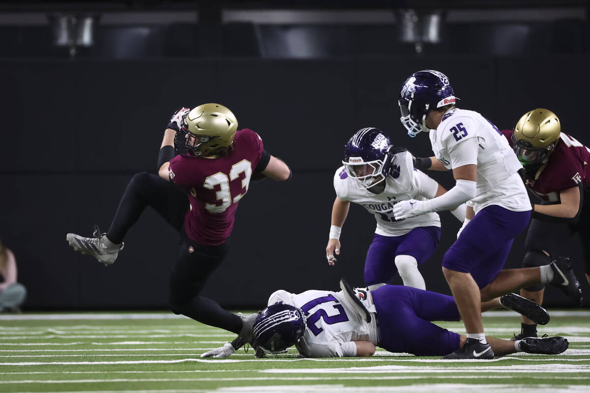 Faith Lutheran running back Justin Robbins (33) runs the ball under pressure from Spanish Sprin ...