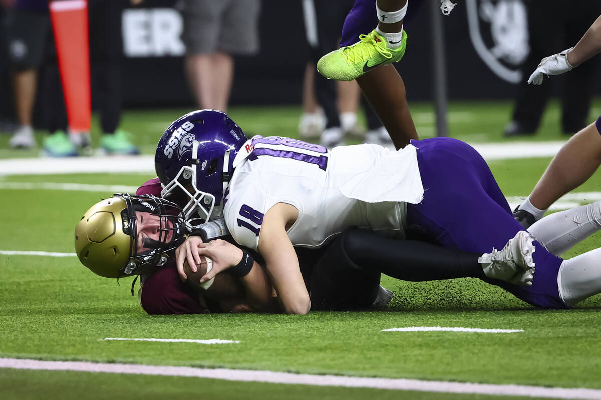 Faith Lutheran quarterback Dominick Folino (14) gets tackled on the run by Spanish Springs free ...