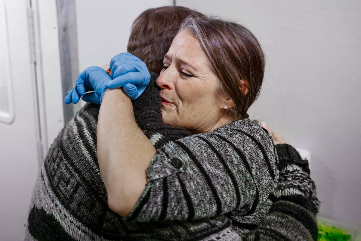 M.J. Anderson, right, hugs a volunteer during holiday meal service at Vegas Stronger Wednesday, ...