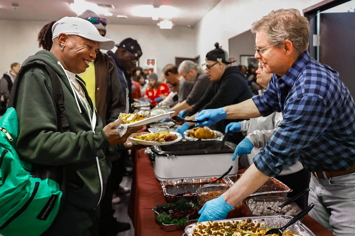 Marc Jackson, right, serves a holiday meal to Cardell Washington at Vegas Stronger Wednesday, N ...