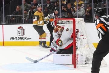 The puck gets stopped just short of crossing the goal line by Ottawa Senators goaltender Linus ...