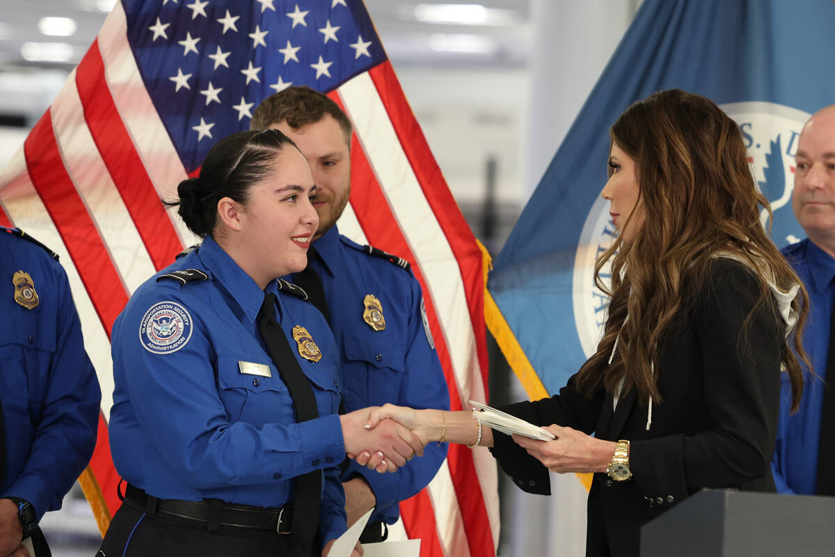 U.S. Homeland Security Secretary Kristi Noem, right, shakes hands with Transportation Security ...