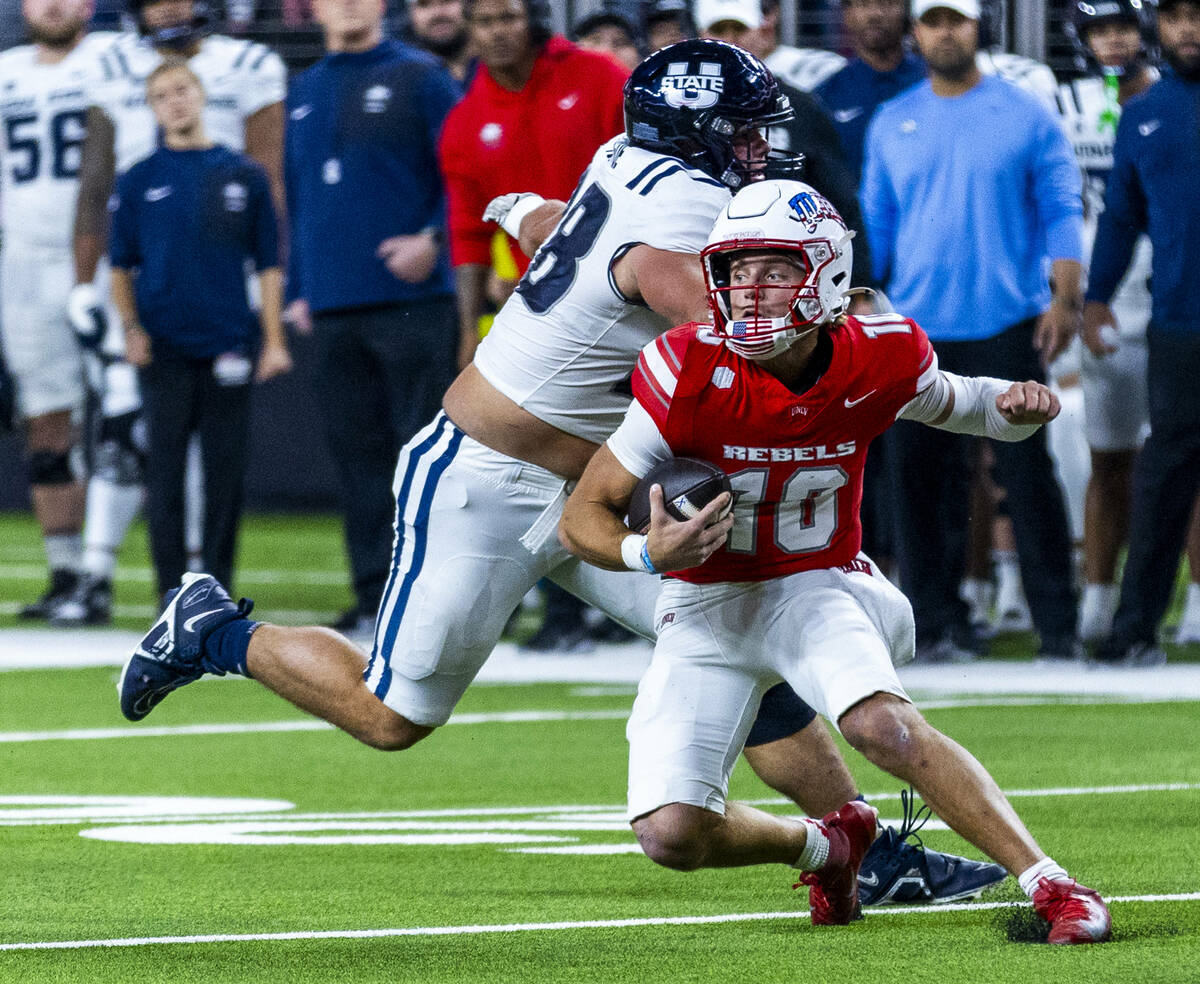 UNLV quarterback Anthony Colandrea (10) cuts back on a run evading Utah State Aggies defensive ...