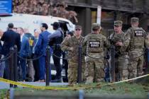 Emergency personnel gather in a cordoned off area where National Guard soldiers were shot near ...
