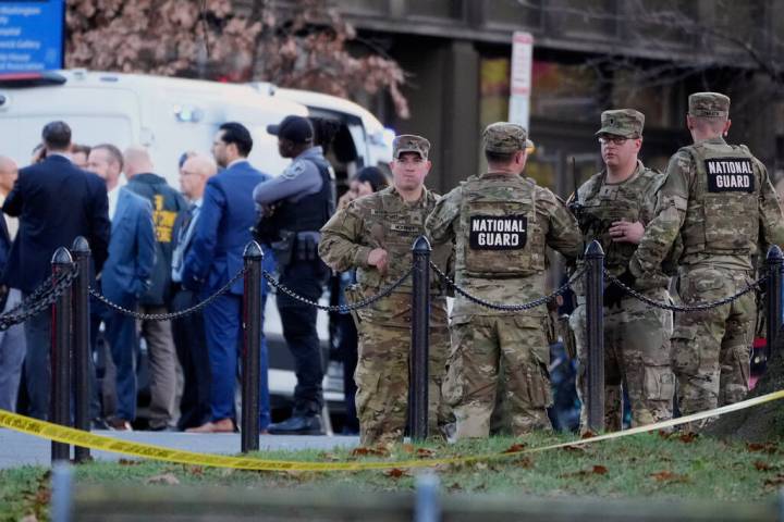 Emergency personnel gather in a cordoned off area where National Guard soldiers were shot near ...