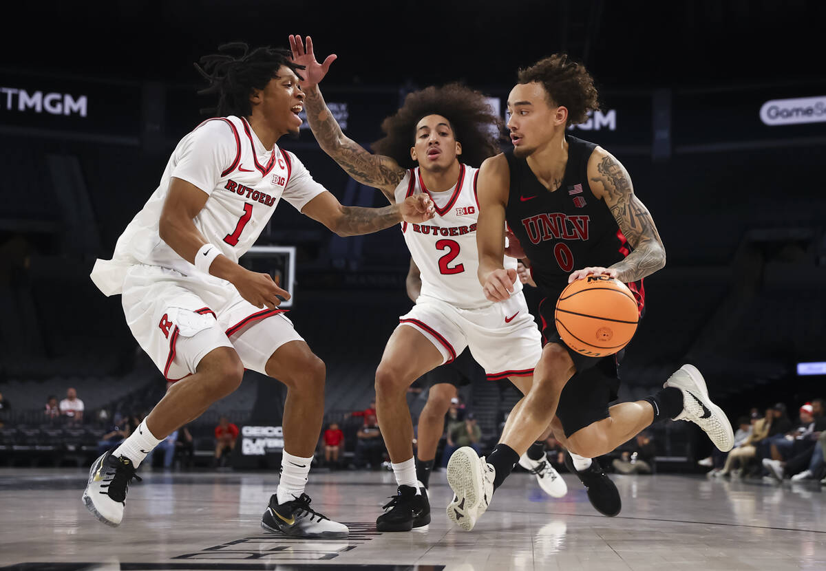 UNLV guard Dravyn Gibbs-Lawhorn (0) drives to the basket as Rutgers guards Jamichael Davis (1) ...