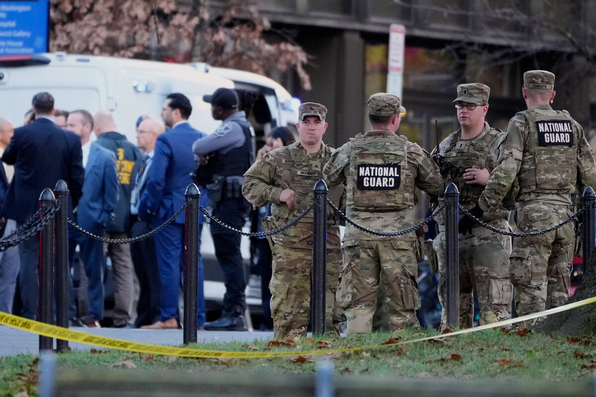 Emergency personnel gather in a cordoned off area where National Guard soldiers were shot near ...
