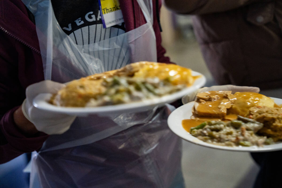 Meals are carried to a table during Catholic Charities of Southern Nevada’s 60th consecu ...