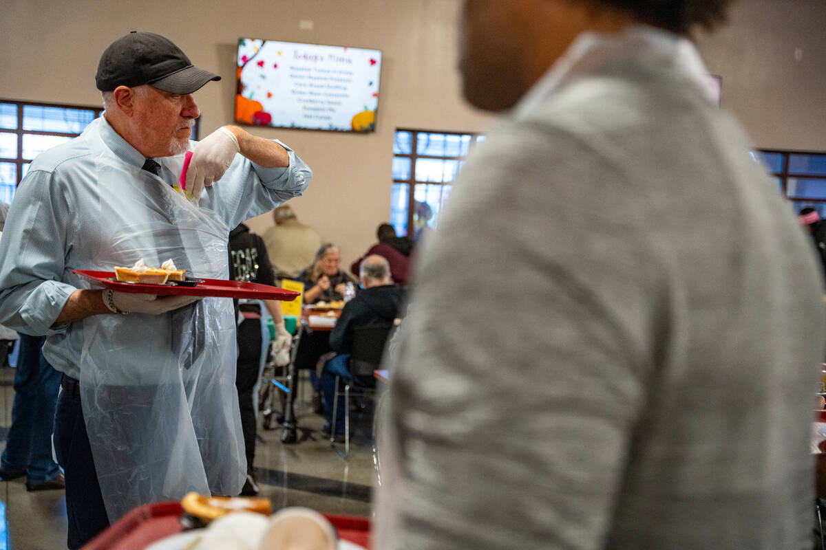Joe Gleason collects a ticket after serving a piece of pumpkin pie during Catholic Charities of ...