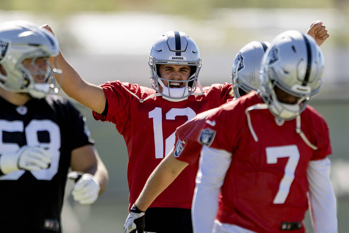 Raiders quarterback Aidan O'Connell (12) warms up near quarterback Geno Smith (7) during t ...