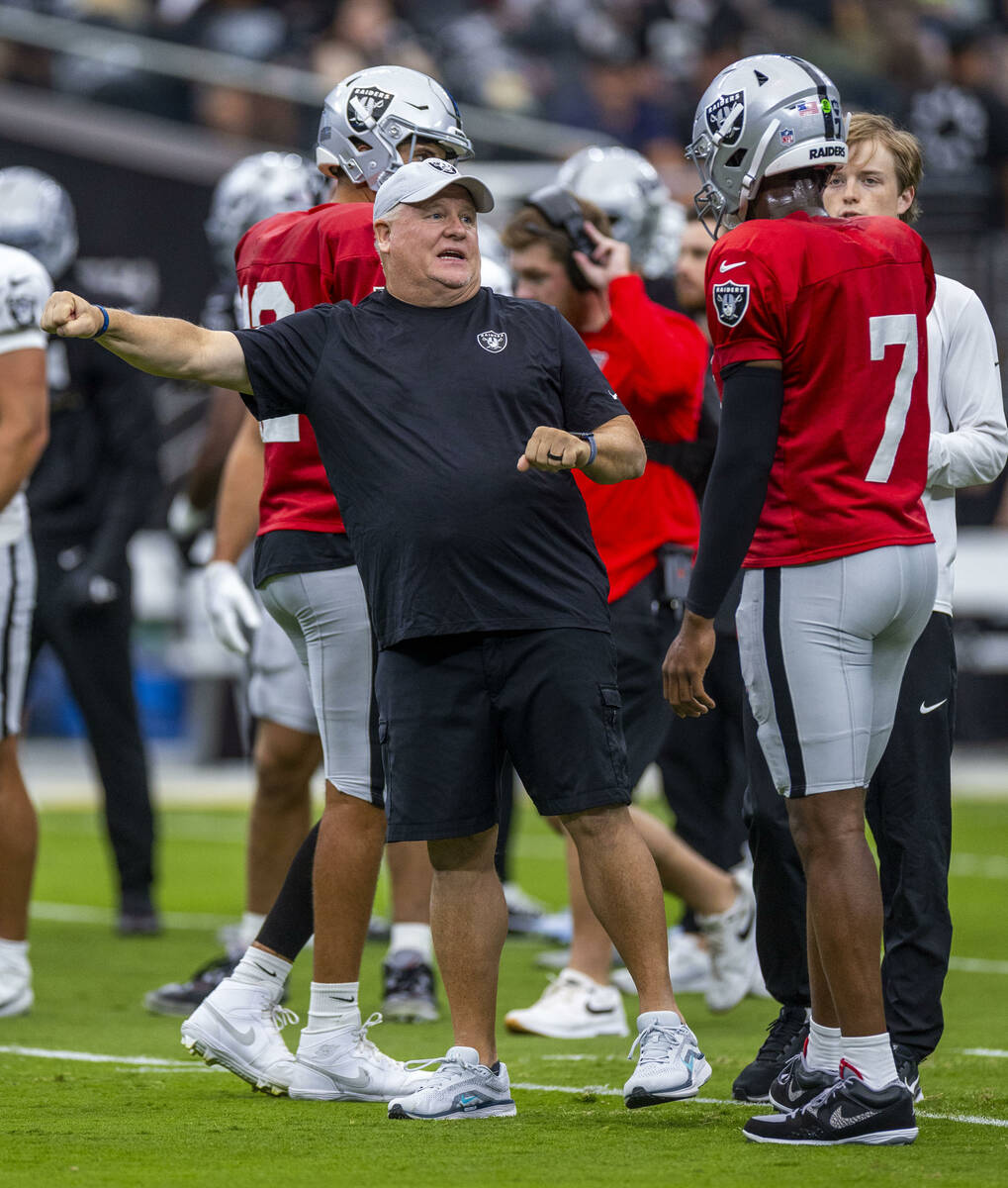 Raiders offensive coordinator Chip Kelly talks with quarterback Geno Smith (7) during the first ...