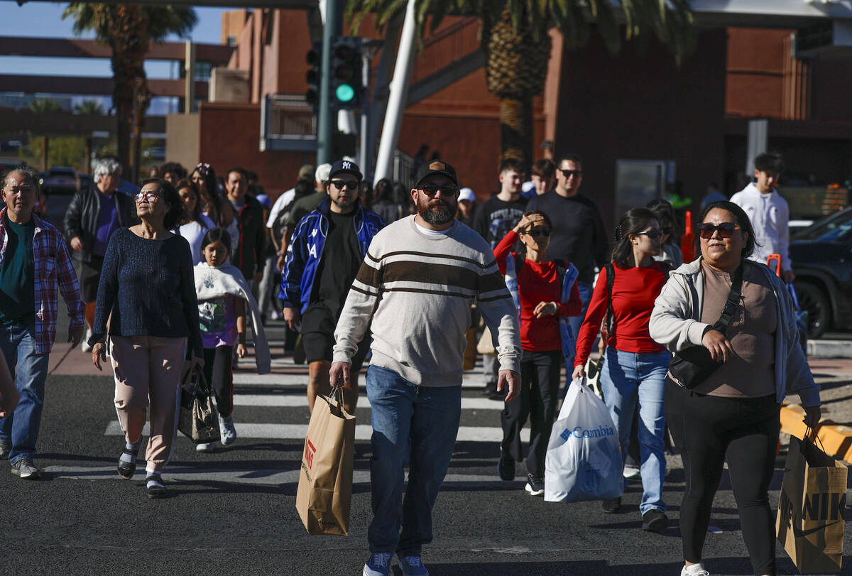 People cross busy streets after finishing shopping during Black Friday at Las Vegas North Premi ...