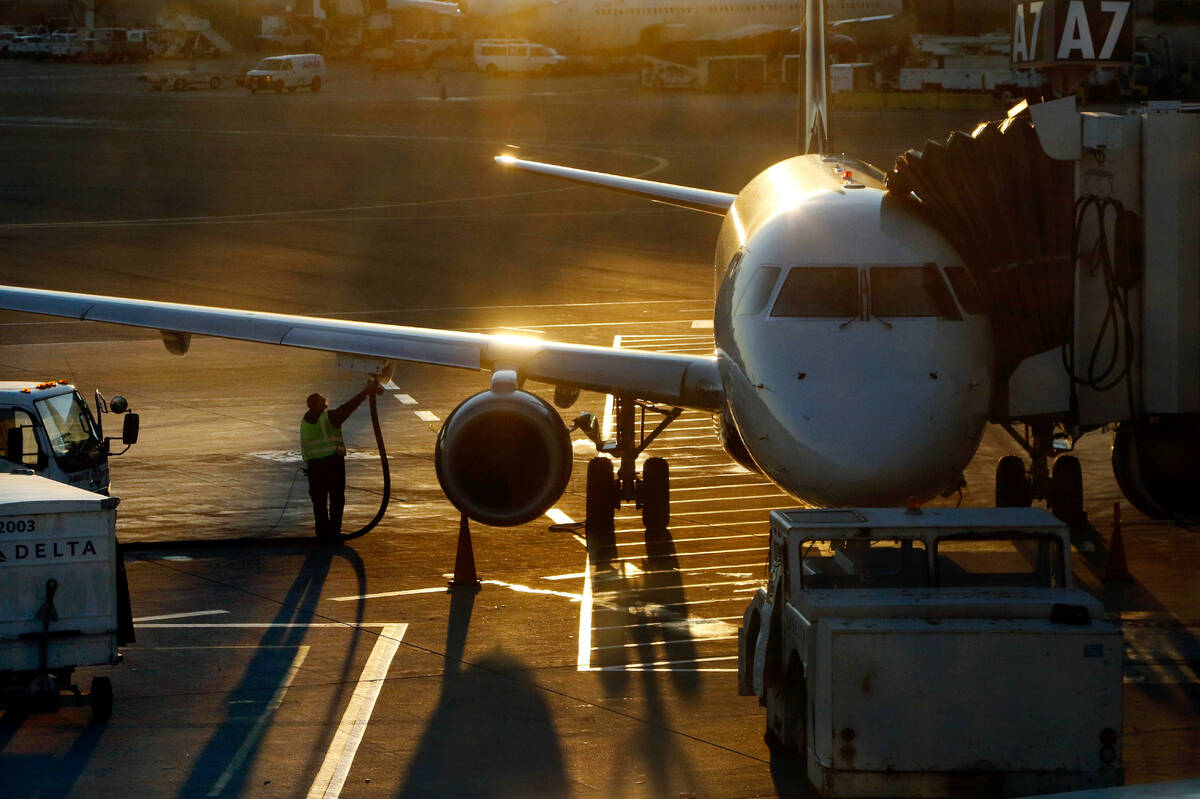 A worker fuels a passenger jet at Logan International Airport, Dec. 8, 2018, in Boston. (AP Pho ...