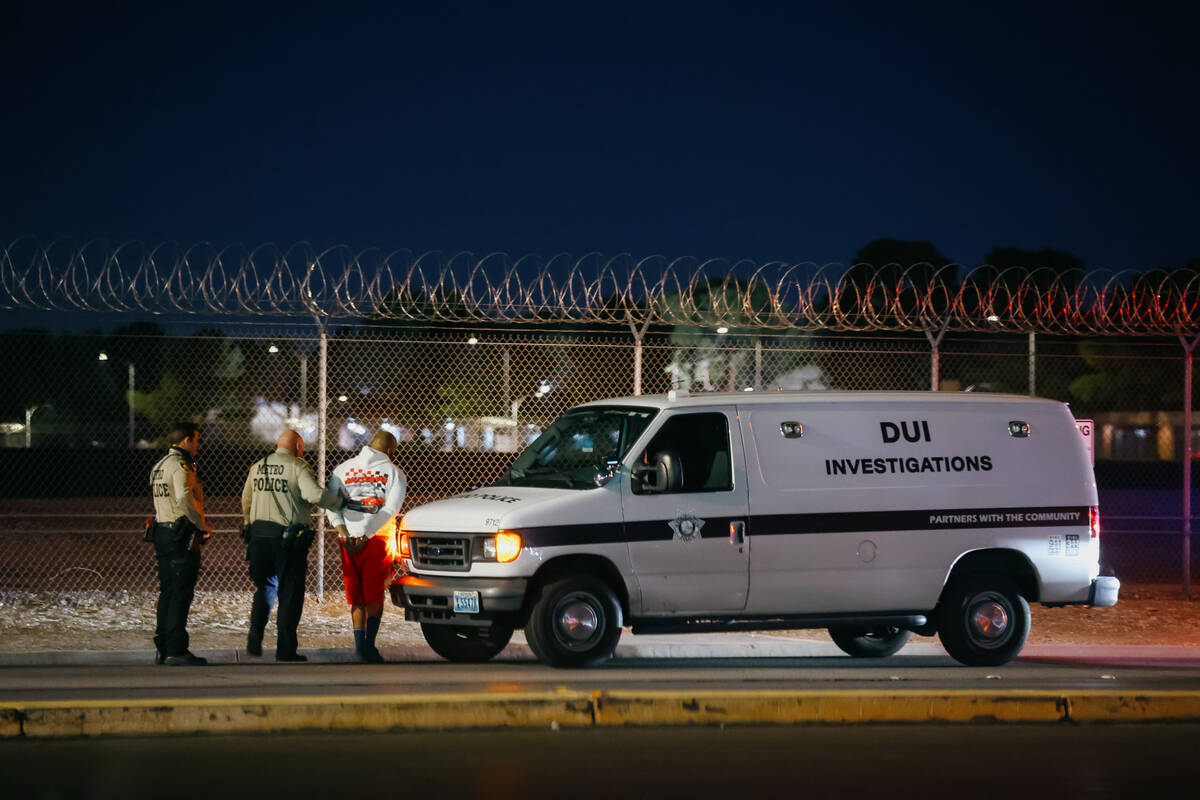 Metropolitan Police Department officers make an arrest along Sunset Road after a DUI blitz was ...