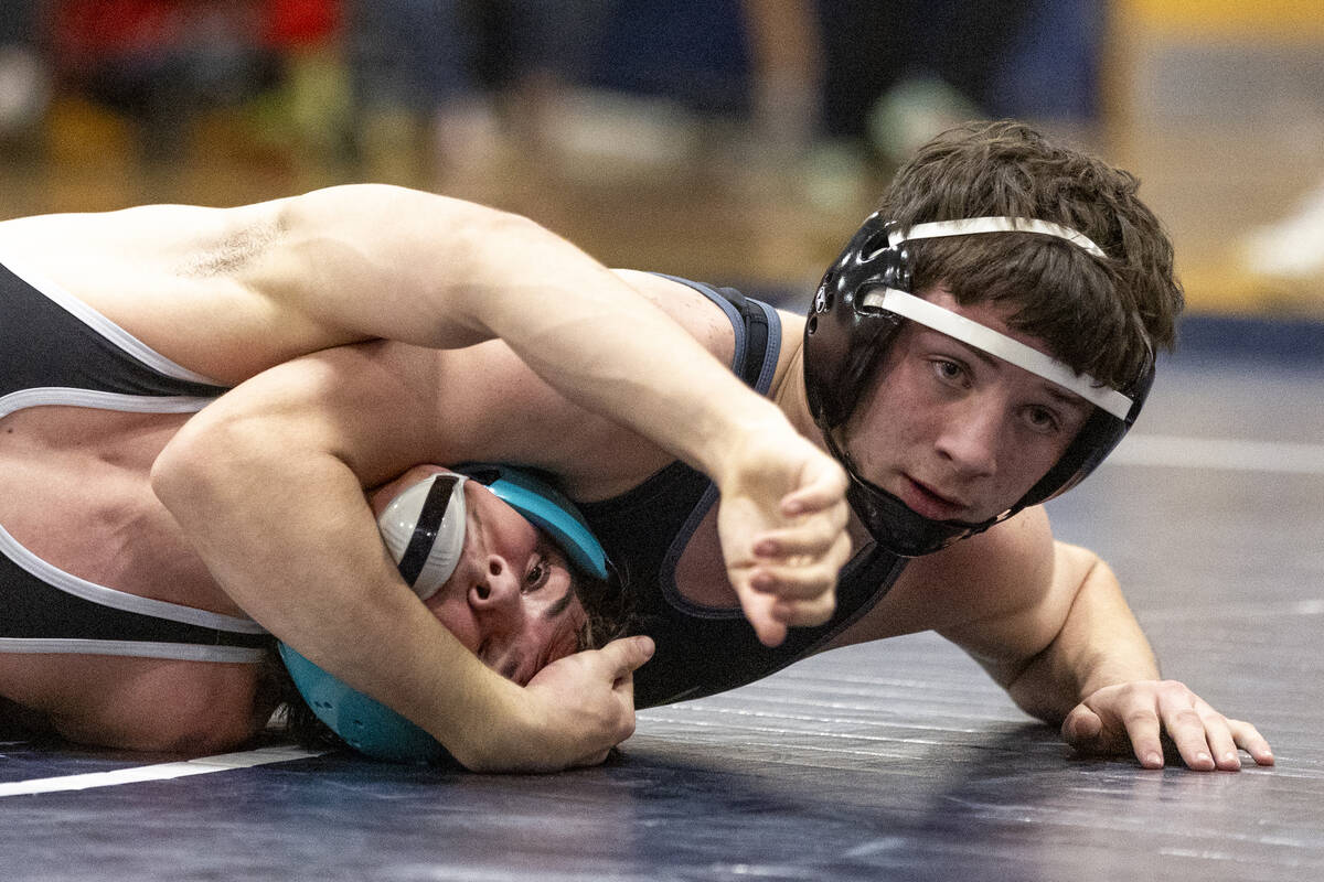 SLAM Academy’s Drake Hooiman, right, places Liberty’s Wyatte Nicholson, left, int ...