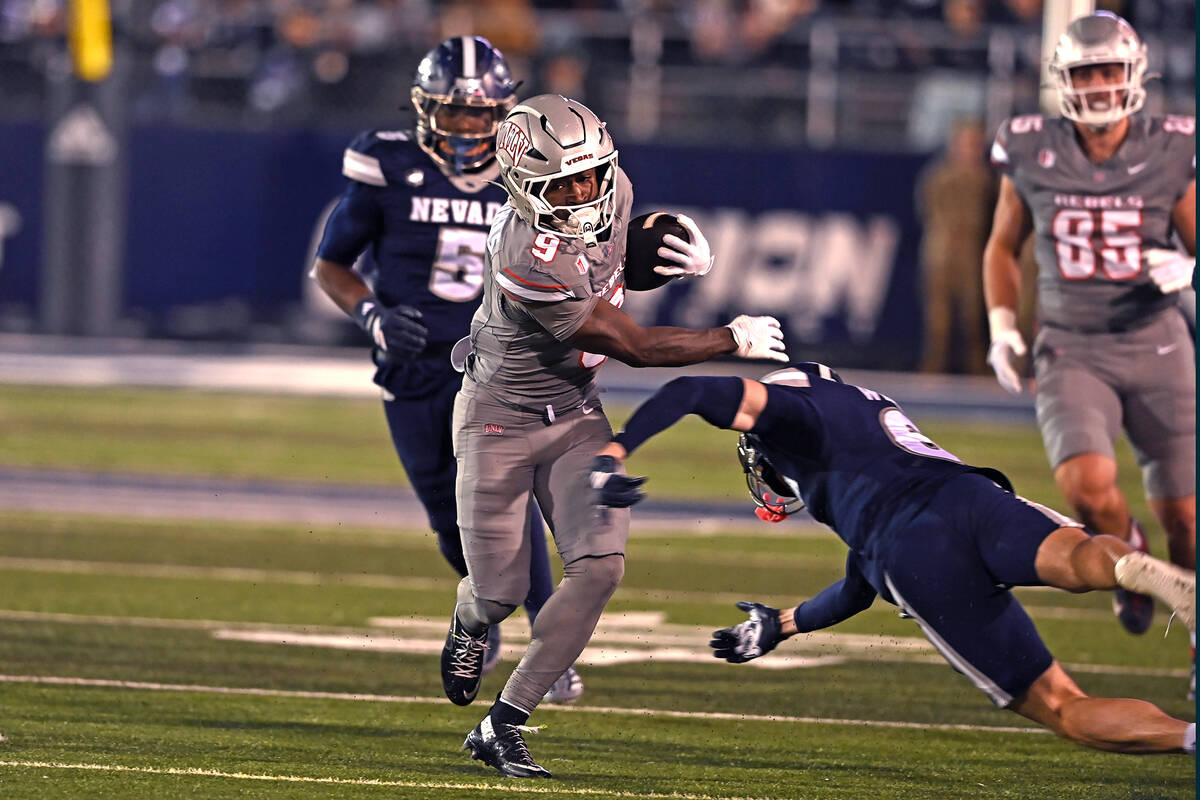 UNLV's Jai'Den Thomas fends off Nevada's Cooper Wilson in the first half of Saturday's game at ...