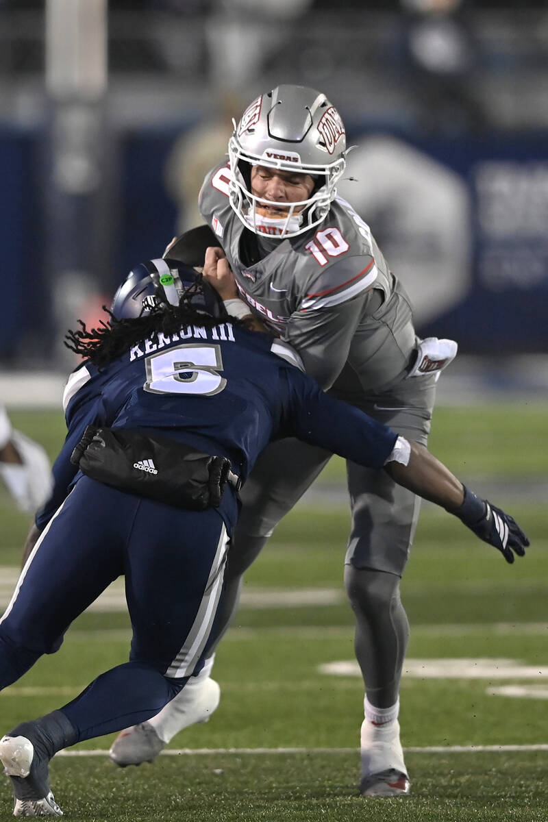 UNLV quarterback Anthony Colandrea takes a hit as run with the ball against Nevada during the f ...