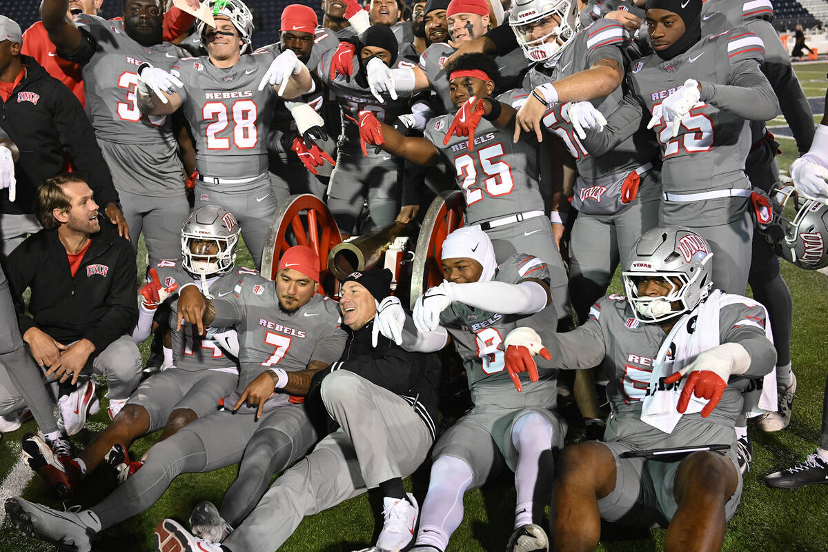 UNLV head football coach Dan Mullen and his players gather around the Fremont Cannon after defe ...