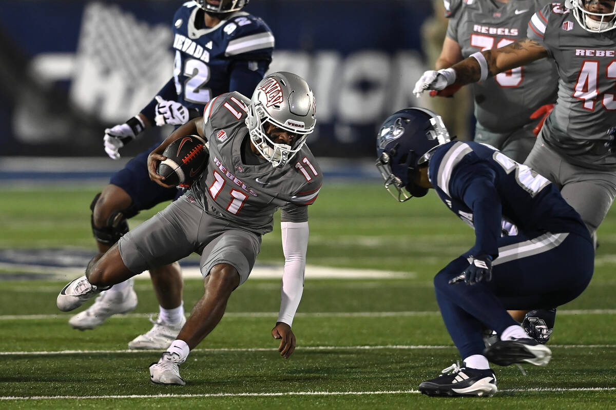 UNLV's Jojo Earle looks to get past Nevada's Isaiah Jordan as he runs the ball during the secon ...