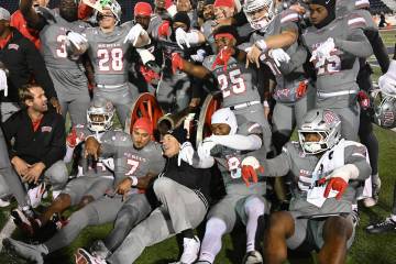 UNLV head football coach Dan Mullen and his players gather around the Fremont Cannon after defe ...