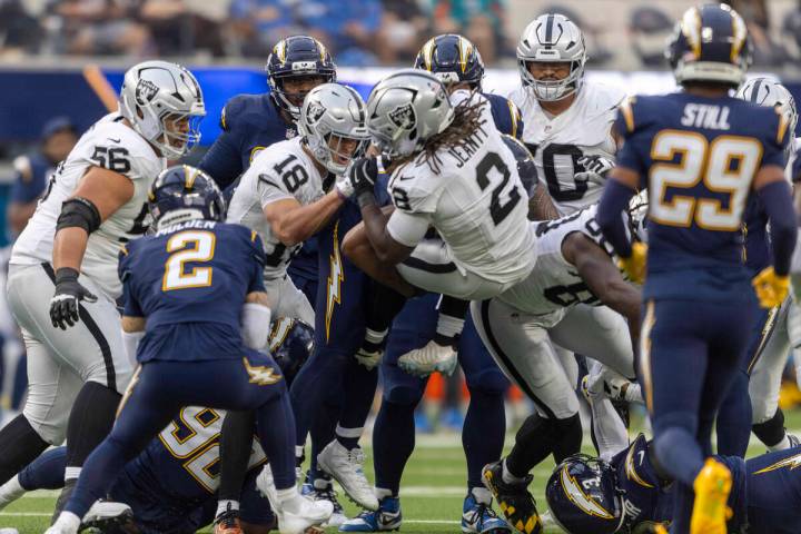 Raiders running back Ashton Jeanty (2) is brought down by Los Angeles Chargers defensive tackle ...
