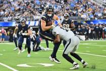 Los Angeles Chargers quarterback Justin Herbert (10) is tackled by Las Vegas Raiders safety Jer ...