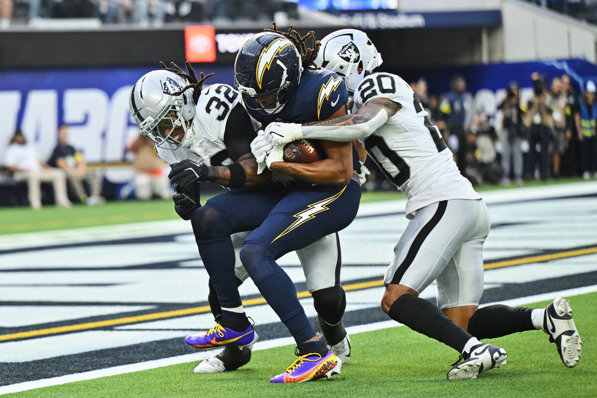 Los Angeles Chargers wide receiver Quentin Johnston, center, scores a touchdown while being tac ...
