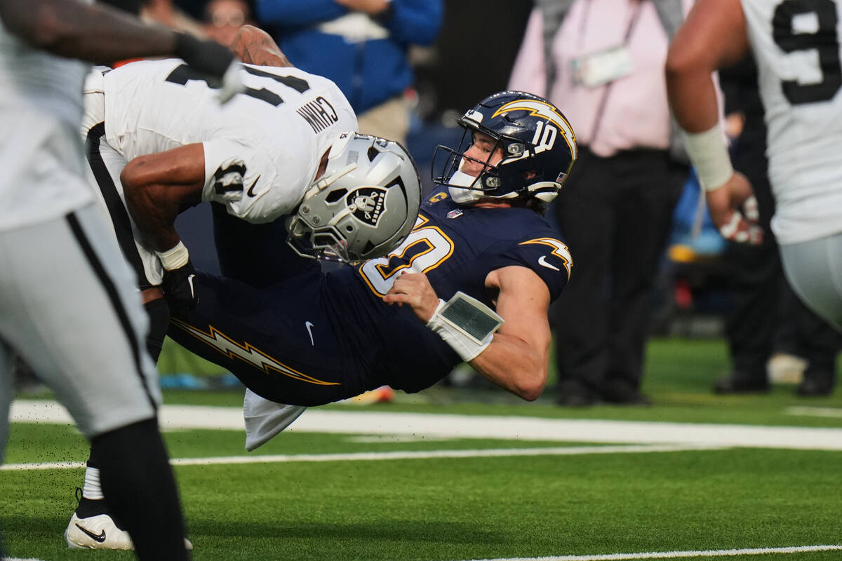 Las Vegas Raiders safety Jeremy Chinn (11) tackles Los Angeles Chargers quarterback Justin Herb ...