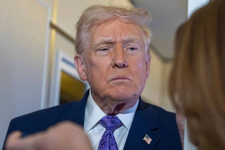 President Donald Trump speaks with reporters while in flight on Air Force One from his Mar-a-La ...