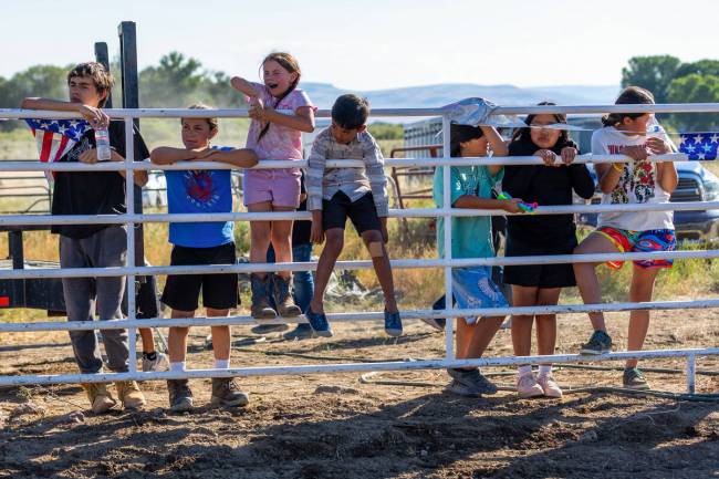 Children watch during a cow riding competition at the 136th birthday celebration on the Fort Mc ...