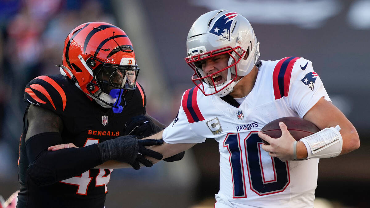 New England Patriots quarterback Drake Maye (10) runs from Cincinnati Bengals linebacker Demetr ...