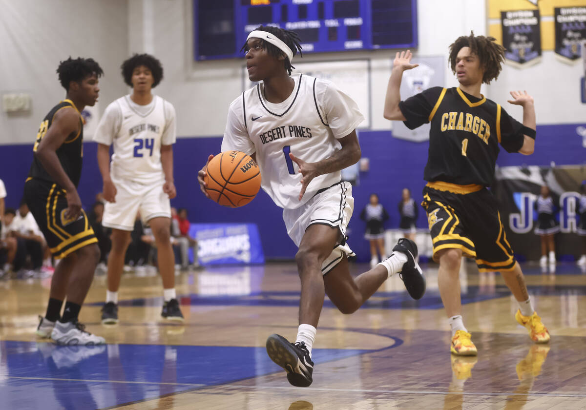 Desert Pines guard Lavelle Lovelace (1) drives to the basket past Clark guard Amir Wright (1) d ...