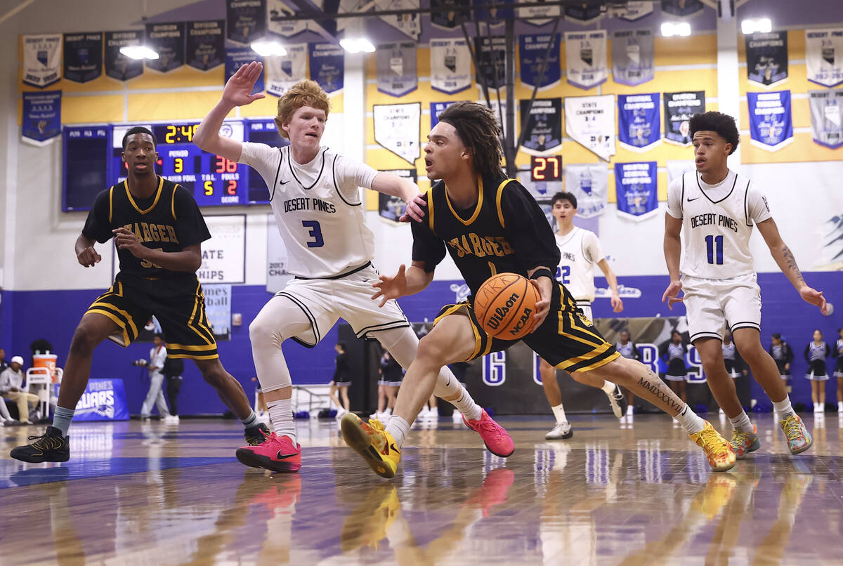 Clark guard Amir Wright (1) drives the ball against Desert Pines forward/center Kru Brown (3) d ...