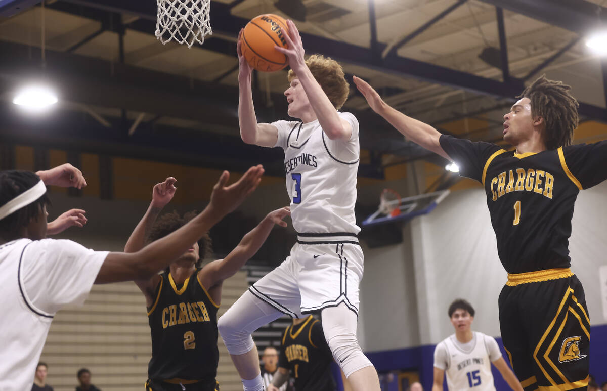Desert Pines forward/center Kru Brown (3) grabs a rebound between Clark point guard/shooting gu ...