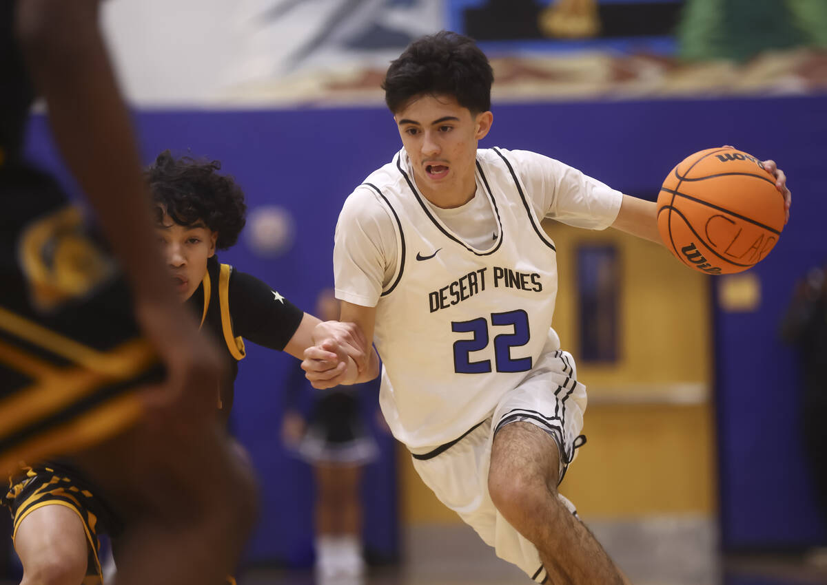 Desert Pines guard Aaron McMorran (22) drives the ball against Clark point guard/shooting guard ...
