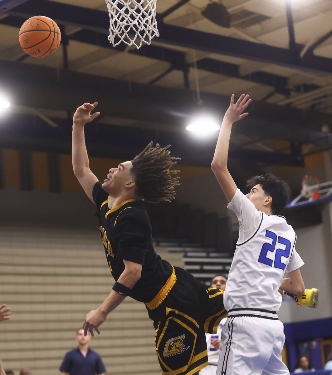 Clark guard Amir Wright (1) lays up the ball past Desert Pines guard Aaron McMorran (22) during ...