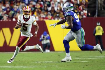 Washington Commanders quarterback Jayden Daniels (5) runs with the ball during an NFL football ...