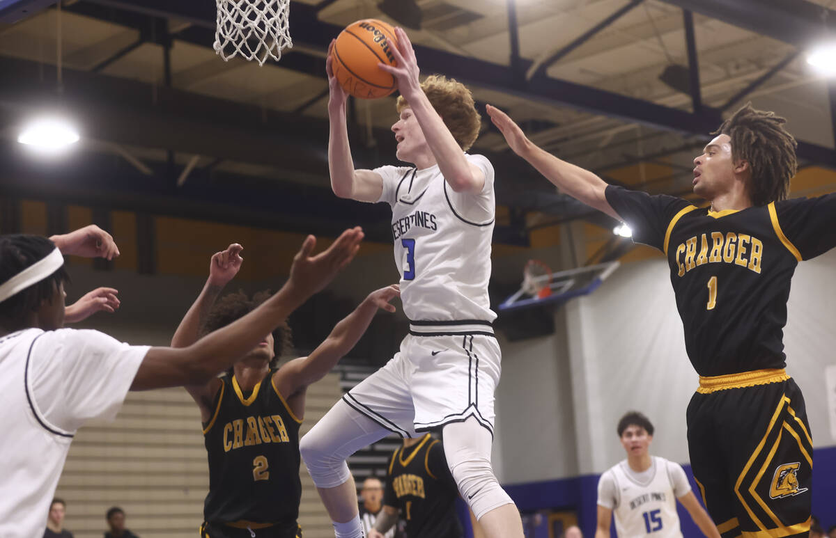 Desert Pines forward/center Kru Brown (3) grabs a rebound between Clark point guard/shooting gu ...