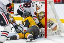 Golden Knights goaltender Carter Hart (79) secures a puck after driven into the goal by Chicago ...