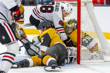 Golden Knights goaltender Carter Hart (79) secures a puck after driven into the goal by Chicago ...