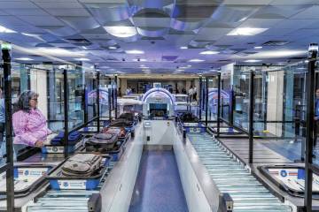 A Transportation Security Administration employee demonstrates a self-service passenger screeni ...