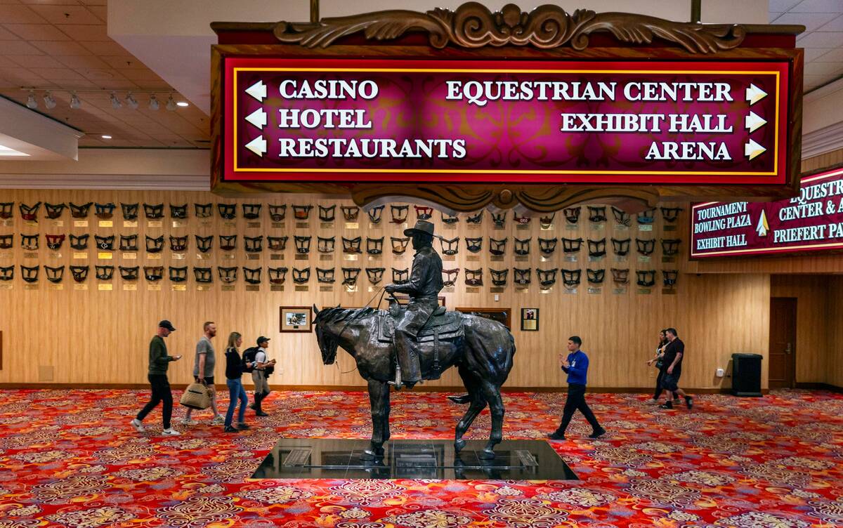 People stream past a statue of Benny Binion atop a horse about a wide walkway in the South Poin ...