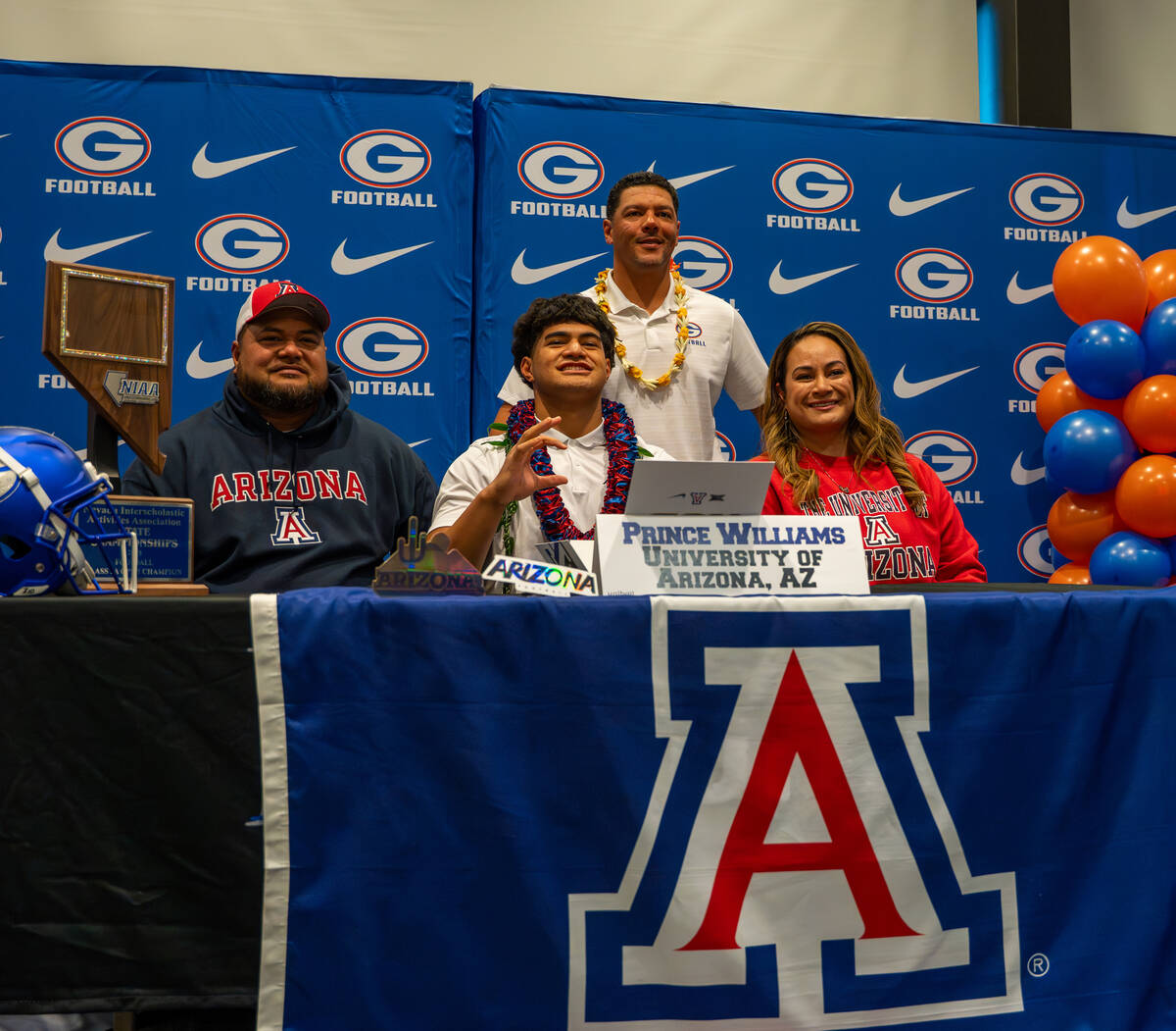 Prince Williams poses for a photo with his coach and family after signing his offer letter to p ...